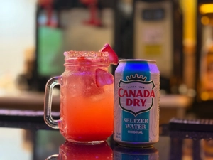 Strawberry flavored soda in a glass mug with strawberry slices and a can of Canada Dry seltzer water in Union City.