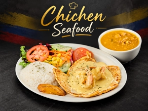 Pechuga marinera con camarones y salsa, acompañada de arroz, plátano y ensalada en un plato. Sopa de mariscos al lado.