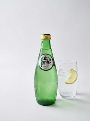 Perrier water bottle next to a glass with ice and a lemon slice in Union City.