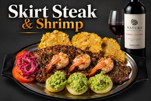Bistec New York con camarones, tostones y guacamole en un plato. Cocina desconocida en ciudad desconocida.