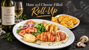 Rollito de pollo con champiñones y tocino, acompañado de ensalada fresca y tostones. Cocina desconocida en ciudad