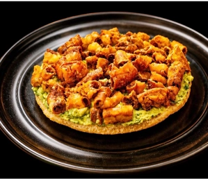 Arepa con chunchurria colombiana con chunchurria frita y aguacate en un plato negro.