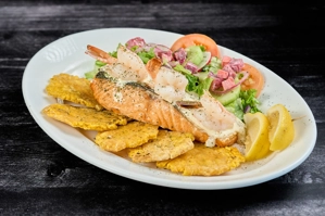 Salmón marinero con camarones y tostones, acompañado de ensalada de lechuga y tomate. Ciudad desconocida.